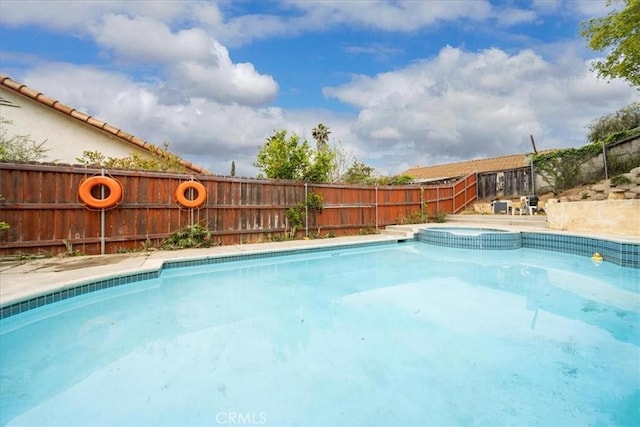 view of swimming pool featuring a fenced backyard and a pool with connected hot tub