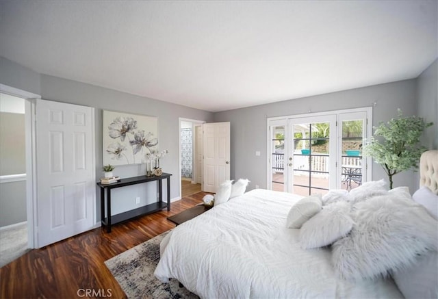 bedroom featuring baseboards, access to exterior, and wood finished floors