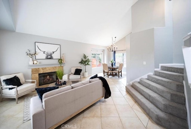 living room featuring stairway, a high end fireplace, an inviting chandelier, light tile patterned flooring, and high vaulted ceiling