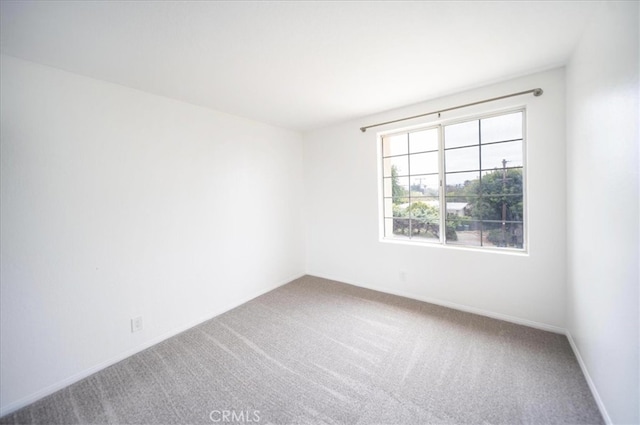carpeted spare room with baseboards