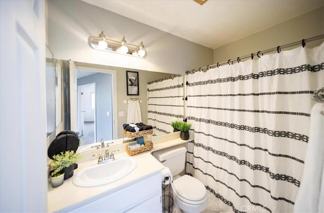 bathroom featuring curtained shower, toilet, and vanity