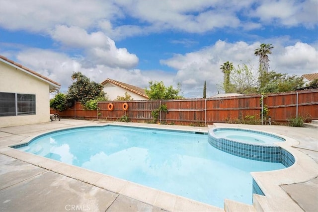 view of pool with a fenced backyard, a pool with connected hot tub, and a patio area