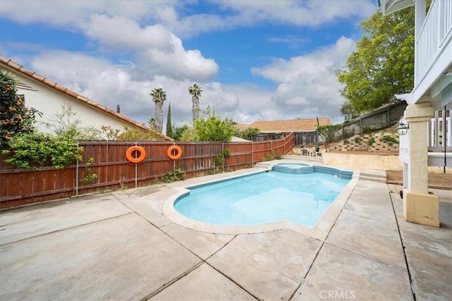 view of pool with a fenced backyard, a pool with connected hot tub, and a patio area