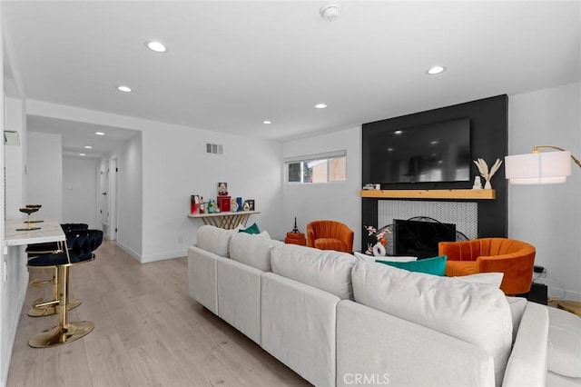living room with visible vents, recessed lighting, light wood finished floors, and baseboards
