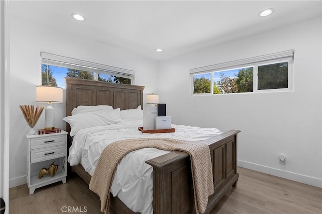 bedroom with light wood-style floors, recessed lighting, and baseboards