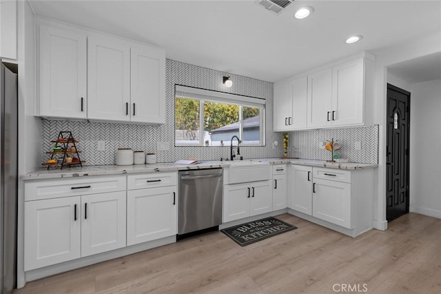 kitchen featuring light stone counters, backsplash, dishwasher, white cabinetry, and visible vents