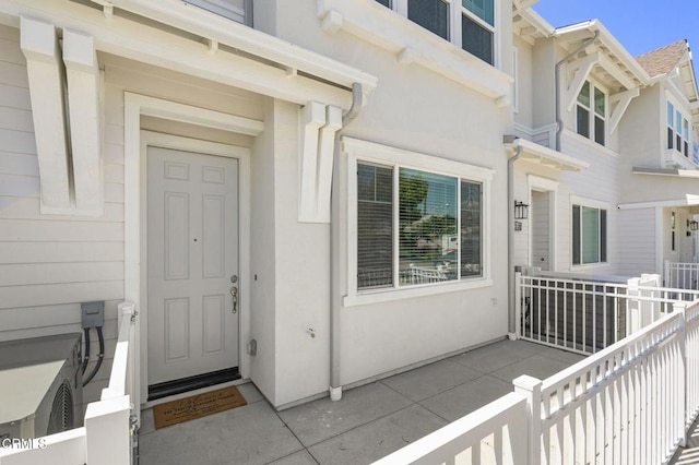 doorway to property featuring stucco siding
