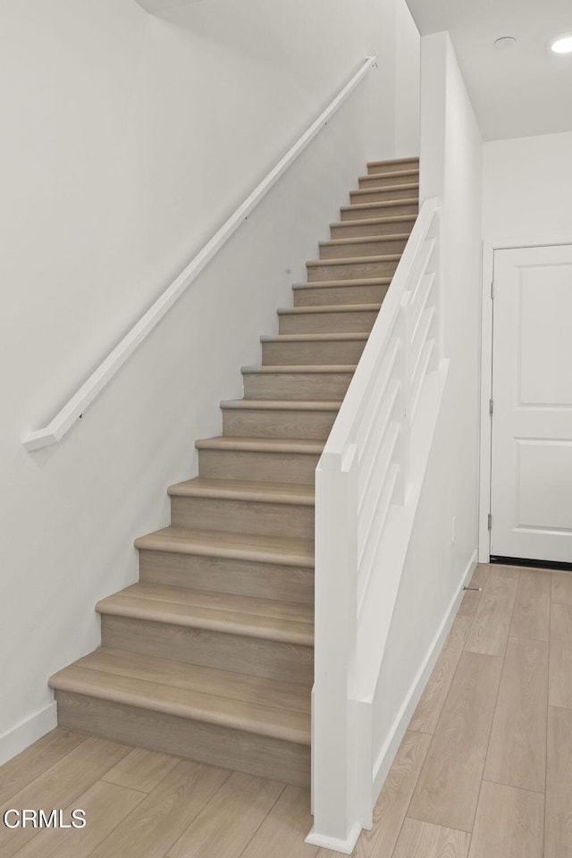 staircase featuring baseboards, recessed lighting, and wood finished floors