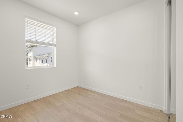 unfurnished room featuring baseboards and light wood finished floors