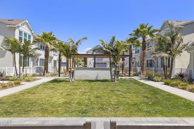 view of community featuring a gazebo, fence, a yard, and a residential view