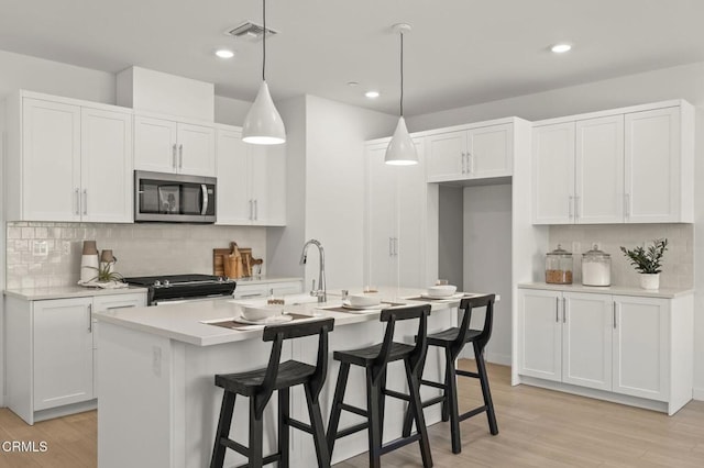kitchen with visible vents, light countertops, white cabinetry, and stainless steel appliances