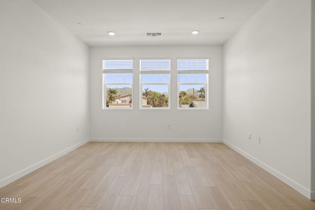 unfurnished room featuring baseboards, plenty of natural light, and visible vents