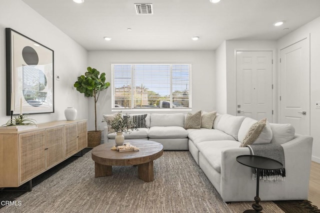 living area with visible vents, recessed lighting, and wood finished floors