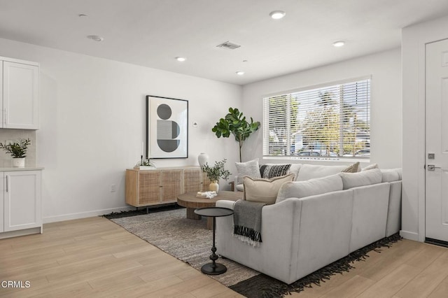 living area with recessed lighting, baseboards, visible vents, and light wood finished floors
