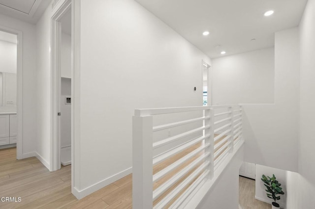 hall featuring recessed lighting, light wood finished floors, baseboards, and an upstairs landing