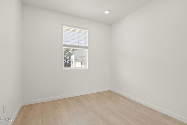 spare room with recessed lighting, baseboards, and light wood-type flooring