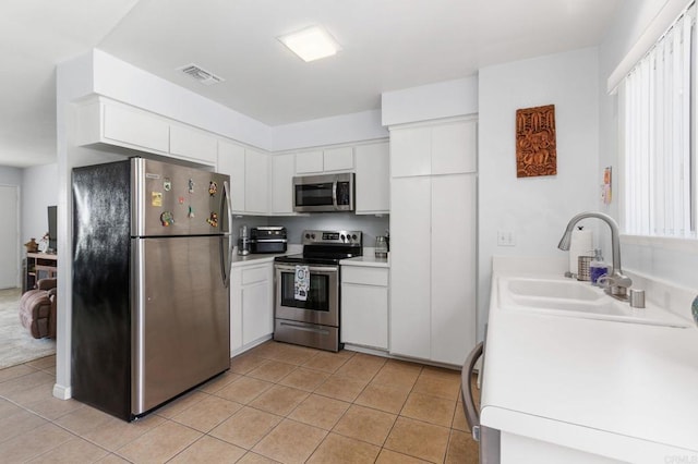 3555 Boussock Ln, Oceanside, CA 92057 - kitchen featuring appliances with stainless steel finishes, light tile patterned flooring, white cabinetry, and light countertops