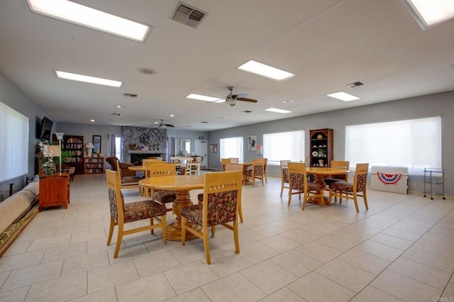 3555 Boussock Ln, Oceanside, CA 92057 - dining room with light tile patterned floors, a fireplace, and a ceiling fan