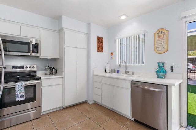 3555 Boussock Ln, Oceanside, CA 92057 - kitchen with appliances with stainless steel finishes, light countertops, light tile patterned floors, white cabinets, and recessed lighting