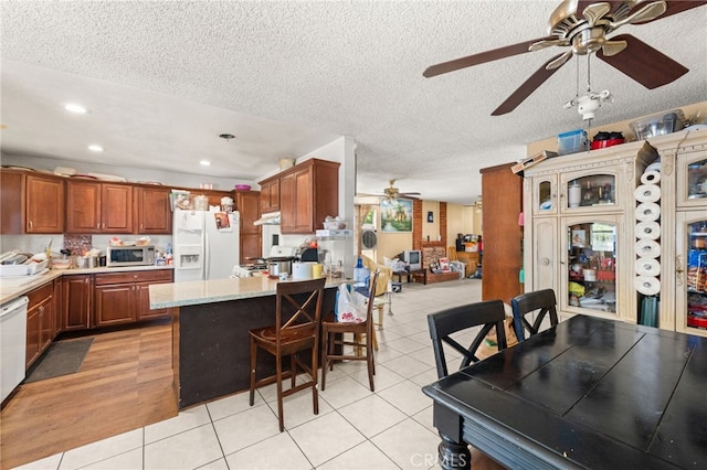 12597 Jalepeno Ave, Chino, CA 91710 - kitchen featuring white appliances, ceiling fan, a peninsula, light tile patterned floors, and recessed lighting