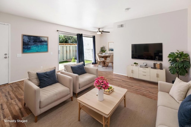 living area with ceiling fan, light wood-type flooring, and visible vents