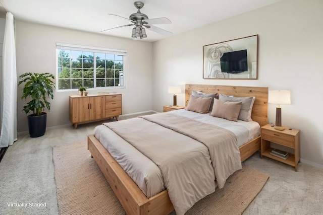 bedroom with a ceiling fan, light colored carpet, and baseboards