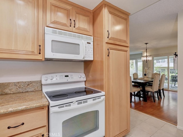 2390 Via Mariposa W Unit 2E, Laguna Woods, CA 92637 - kitchen with light tile patterned floors, a notable chandelier, light brown cabinets, and white appliances