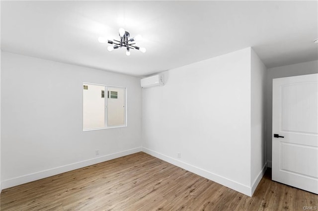 11445 Saticoy St, North Hollywood, CA 91605 - spare room with a wall mounted AC, baseboards, wood finished floors, and a chandelier