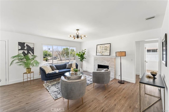 11445 Saticoy St, North Hollywood, CA 91605 - living room with a chandelier, wood finished floors, a fireplace, and baseboards