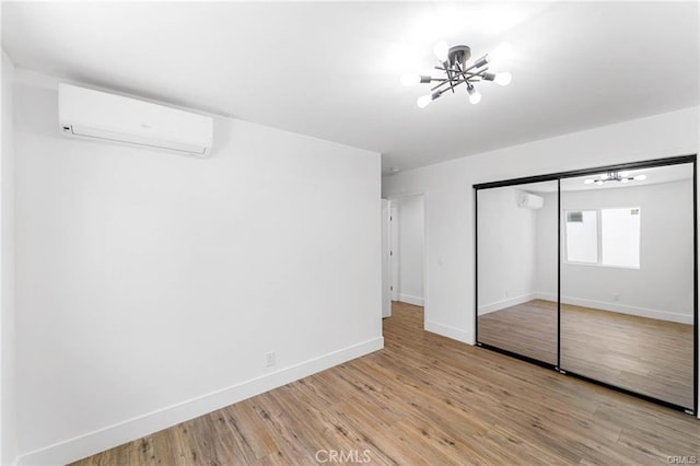 11445 Saticoy St, North Hollywood, CA 91605 - unfurnished bedroom featuring a wall mounted AC, a chandelier, baseboards, and light wood finished floors
