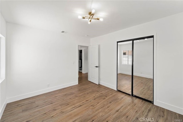 11445 Saticoy St, North Hollywood, CA 91605 - unfurnished bedroom featuring a chandelier, wood finished floors, baseboards, and a closet