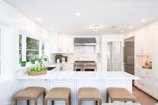 567 Flora St, Laguna Beach, CA 92651 - kitchen featuring wall chimney range hood, decorative backsplash, a sink, visible vents, and high end appliances