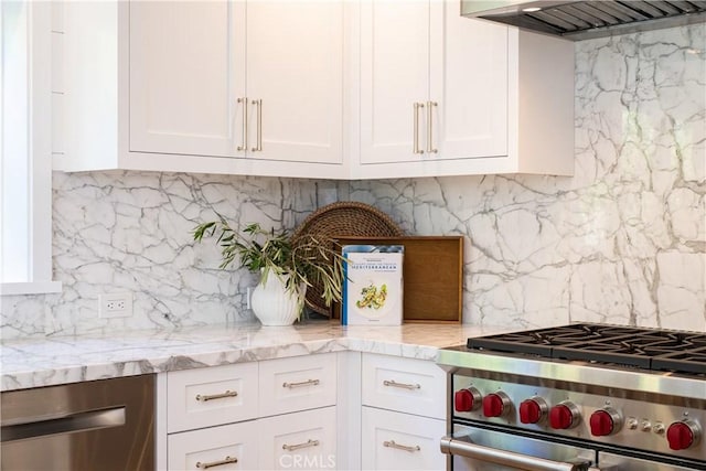 567 Flora St, Laguna Beach, CA 92651 - kitchen featuring tasteful backsplash, light stone countertops, stainless steel appliances, wall chimney range hood, and white cabinets