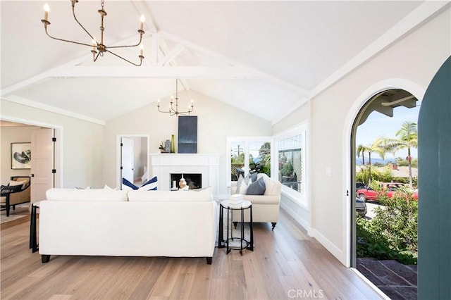 567 Flora St, Laguna Beach, CA 92651 - living room featuring a chandelier, baseboards, lofted ceiling with beams, and light wood-style floors