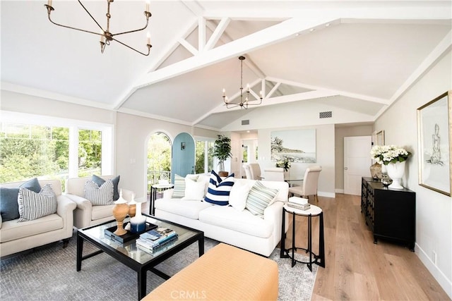 567 Flora St, Laguna Beach, CA 92651 - living area with lofted ceiling, light wood-style flooring, visible vents, baseboards, and an inviting chandelier