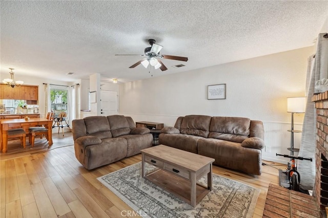 1045 Clover Ln, Hanford, CA 93230 - living area with light wood-style floors, a textured ceiling, a ceiling fan, and a chandelier