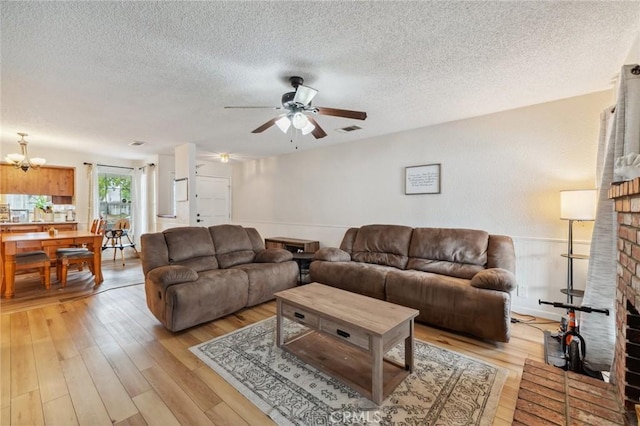 1045 Clover Ln, Hanford, CA 93230 - living area with light wood-type flooring, a textured ceiling, a ceiling fan, and a chandelier