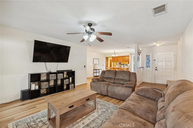 1045 Clover Ln, Hanford, CA 93230 - living room featuring ceiling fan, a chandelier, wood finished floors, a textured ceiling, and baseboards