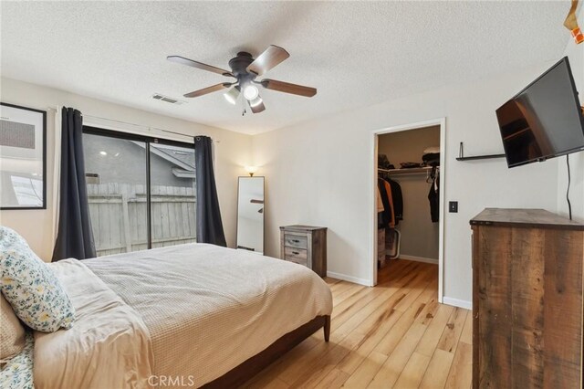 1045 Clover Ln, Hanford, CA 93230 - bedroom featuring wood finished floors, a walk in closet, a textured ceiling, ceiling fan, and a closet