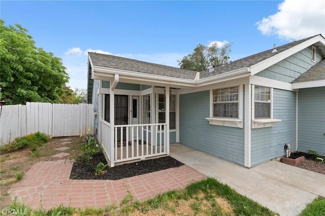 1045 Clover Ln, Hanford, CA 93230 - rear view of house featuring fence, covered porch, and roof with shingles