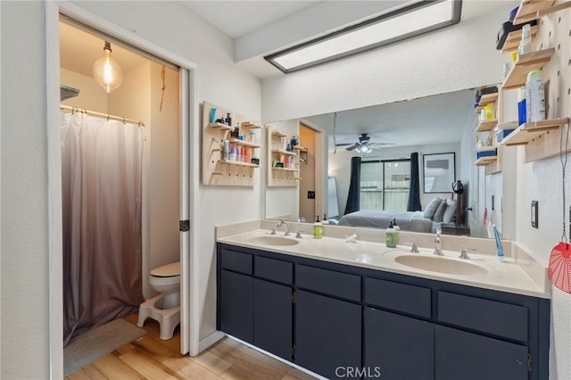 1045 Clover Ln, Hanford, CA 93230 - bathroom with wood finished floors, double vanity, ceiling fan, ensuite bathroom, and a shower with curtain
