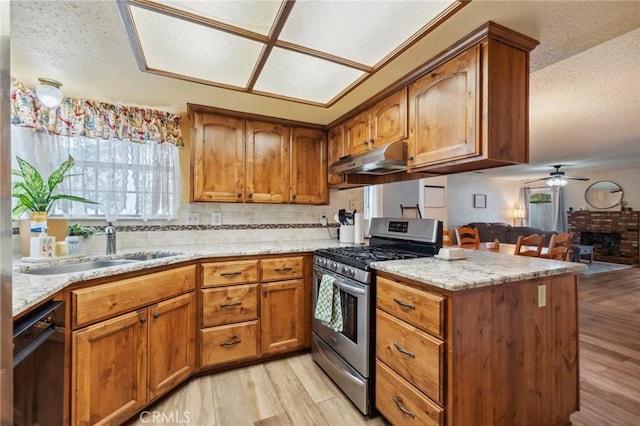 1045 Clover Ln, Hanford, CA 93230 - kitchen featuring stainless steel range with gas stovetop, black dishwasher, ceiling fan, light wood-style floors, and brown cabinets