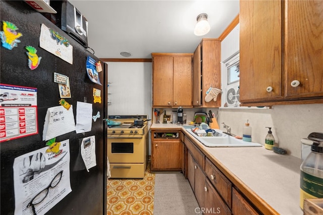 12652 Oaks Ave, Chino, CA 91710 - kitchen with freestanding refrigerator, gas stove, light countertops, brown cabinetry, and a sink