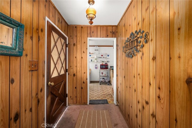 corridor with wood walls and carpet floors