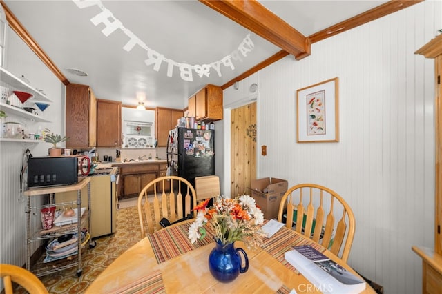 dining space featuring beam ceiling and crown molding