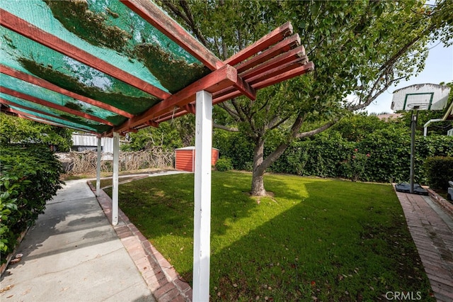 view of grassy yard featuring a storage unit, an outbuilding, and a pergola