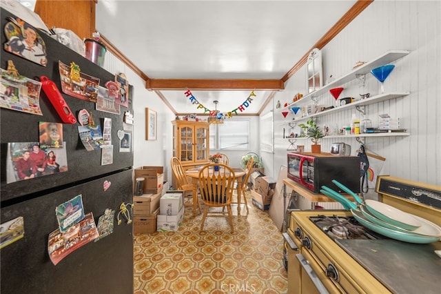 kitchen with freestanding refrigerator, open shelves, stainless steel gas range, wood walls, and ornamental molding