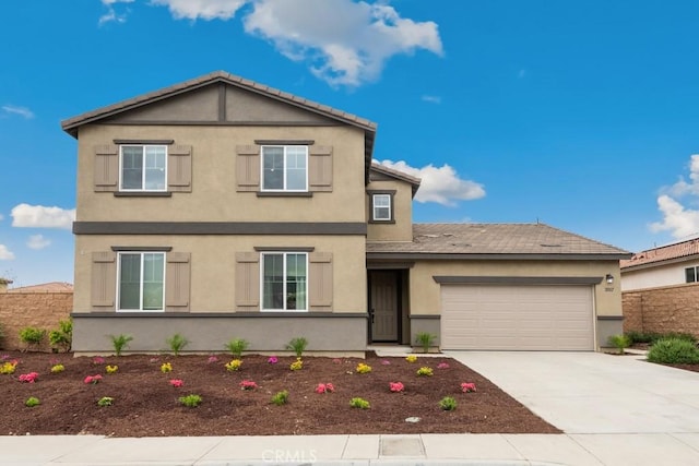 traditional-style house featuring concrete driveway, stucco siding, and a garage
