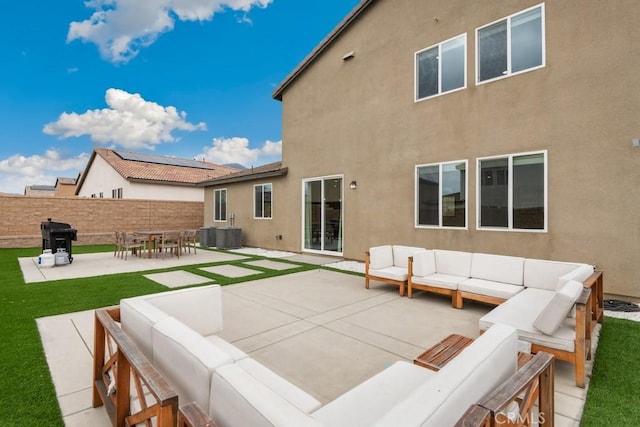 rear view of house with an outdoor living space, a patio area, stucco siding, and a yard