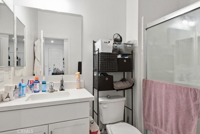 bathroom featuring vanity, a stall shower, and toilet